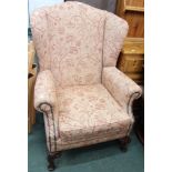 A substantial re-upholstered wing back armchair