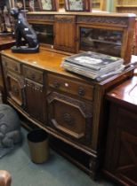An early 20th century oak carved sideboard with three drawers over two cupboard doors