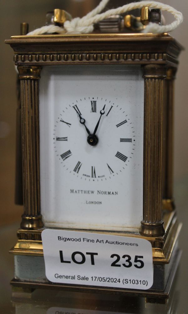A "Matthew Norman" carriage clock, brass column framed five glass case, with hinged bale handle and