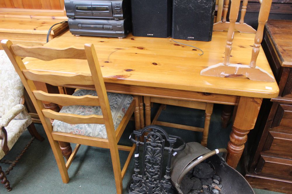 A small pine kitchen table with four beech and drop-in upholstered chairs