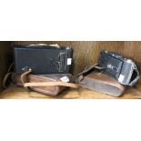 A box containing two vintage cameras in original leather cases