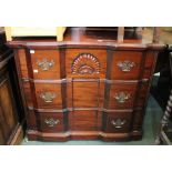 A reproduction set of hard wood chest of three drawers with brass drop handles and carved
