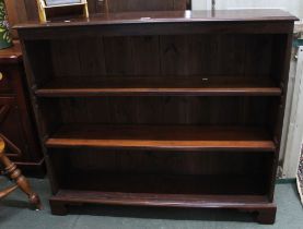A mahogany open front bookcase with adjustable shelves, panel back on bracket feet