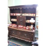 A 19th century carved oak two door dresser with green man style carvings and single door