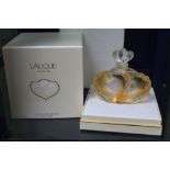 A Lalique perfume bottle, designed as conjoined hearts, still full and in original packaging, with l