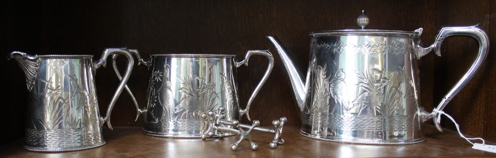 A three piece silver plated Walker & Hall metal tea set, decorated with Herons catching fish, togeth