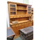 A modern pine large sized dresser with four in-line drawers over four cupboards. Large and partly