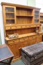 A modern pine large sized dresser with four in-line drawers over four cupboards. Large and partly