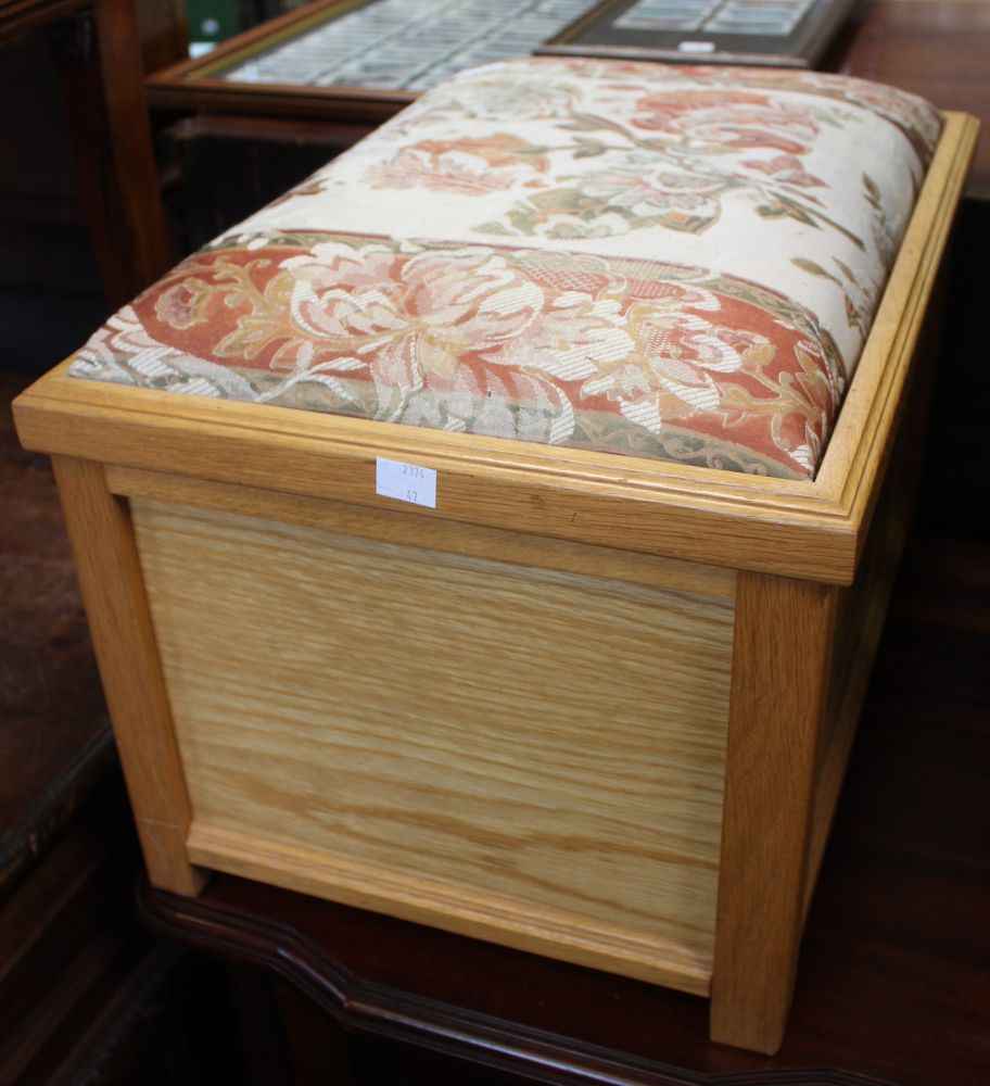 A small wooden box with upholstered top