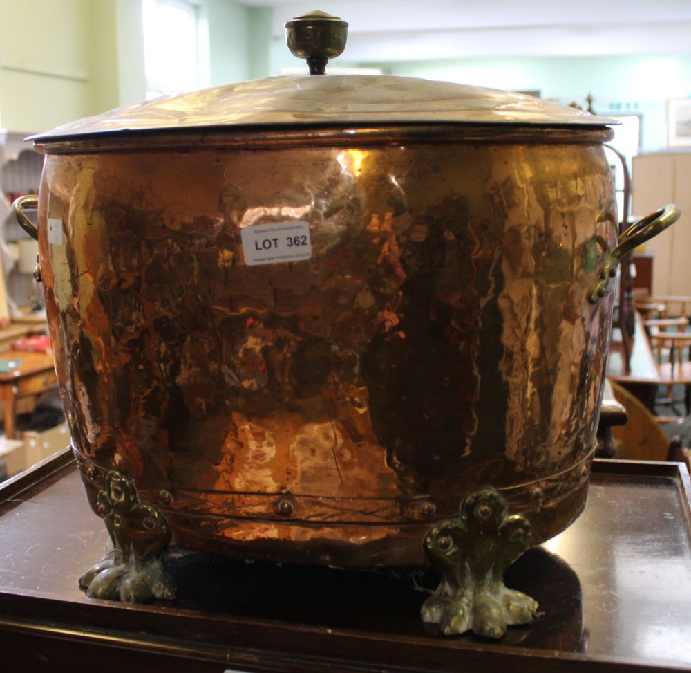 A large oval copper and brass twin handled and lidded coal bucket on lion paw feet