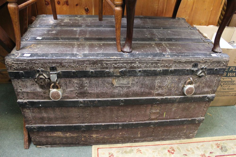 A large flat topped metal bound trunk