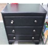 A small black painted chest of three drawers