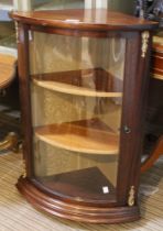A reproduction corner display cabinet with bow glass door and brass decoration