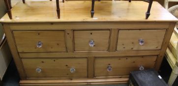 A long low old pine chest of three over two drawers with later glass knobs