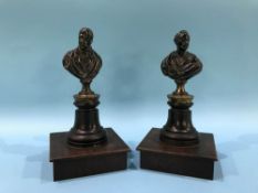 A pair of small metalware decorative figural one quarter length busts of Gentlemen, on turned stands