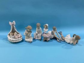 A Lladro group of two babies in a crib and five Nao figures