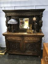 A heavily carved oak mirror back sideboard, W 152cm