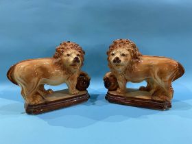 A pair of Staffordshire standing lions with glass eyes