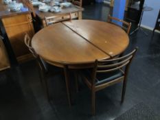 A circular extending table with four dining chairs
