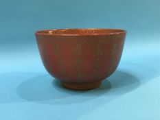 A small Chinese bowl on a terracotta ground, with gilt writing and marks in underglaze red, D 13cm