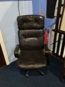 A retro brown leather and chrome swivel armchair