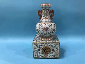 An unusual Chinese Famille Rose two handled vase, supported on a square and pierced base, mark in