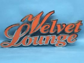 A chrome advertising sign 'Velvet Lounge'