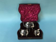 A cased silver three piece tea set, 18 ozt, London marks rubbed