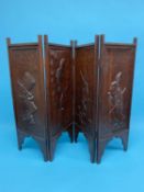 A small carved oak four fold screen, each panel depicting characters from Alice in Wonderland,