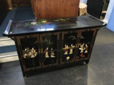 An Oriental lacquered four door side cabinet, W 136cm