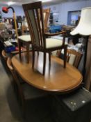 A teak bookcase and modern dining table with six chairs
