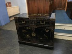 An Oriental lacquered cabinet, with two short drawers, below two cupboard doors, W 91cm