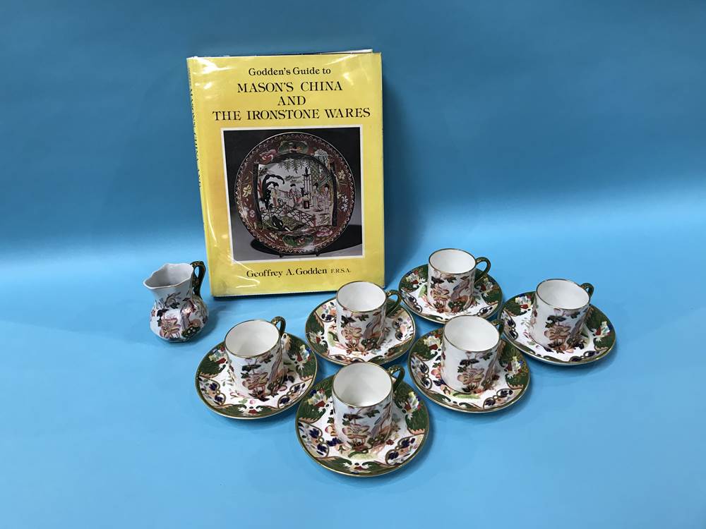 A set of six Masons Ironstone coffee cans and saucers, a milk jug and G Godden's 'Guide to Masons'