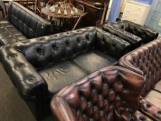 A black Chesterfield settee and club armchair