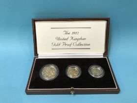 A boxed UK Royal Mint 1983 gold proof three coin set, including a £2 coin, a sovereign and a half