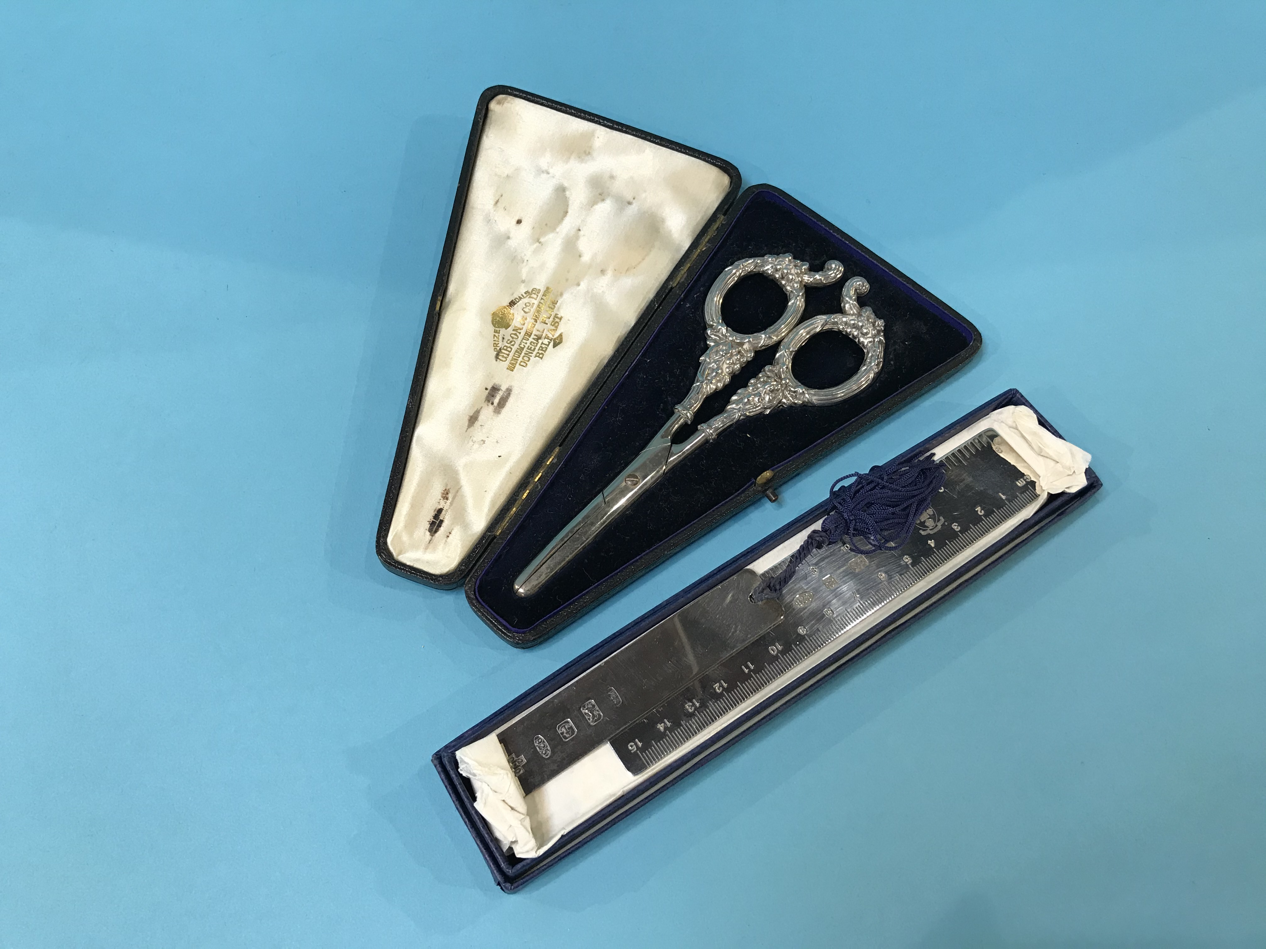 Cased pair of silver handled grape scissors, a silver rule and a silver bookmark