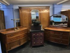 An Edwardian mahogany bedroom suite comprising of a triple door wardrobe, dressing chest and a chest