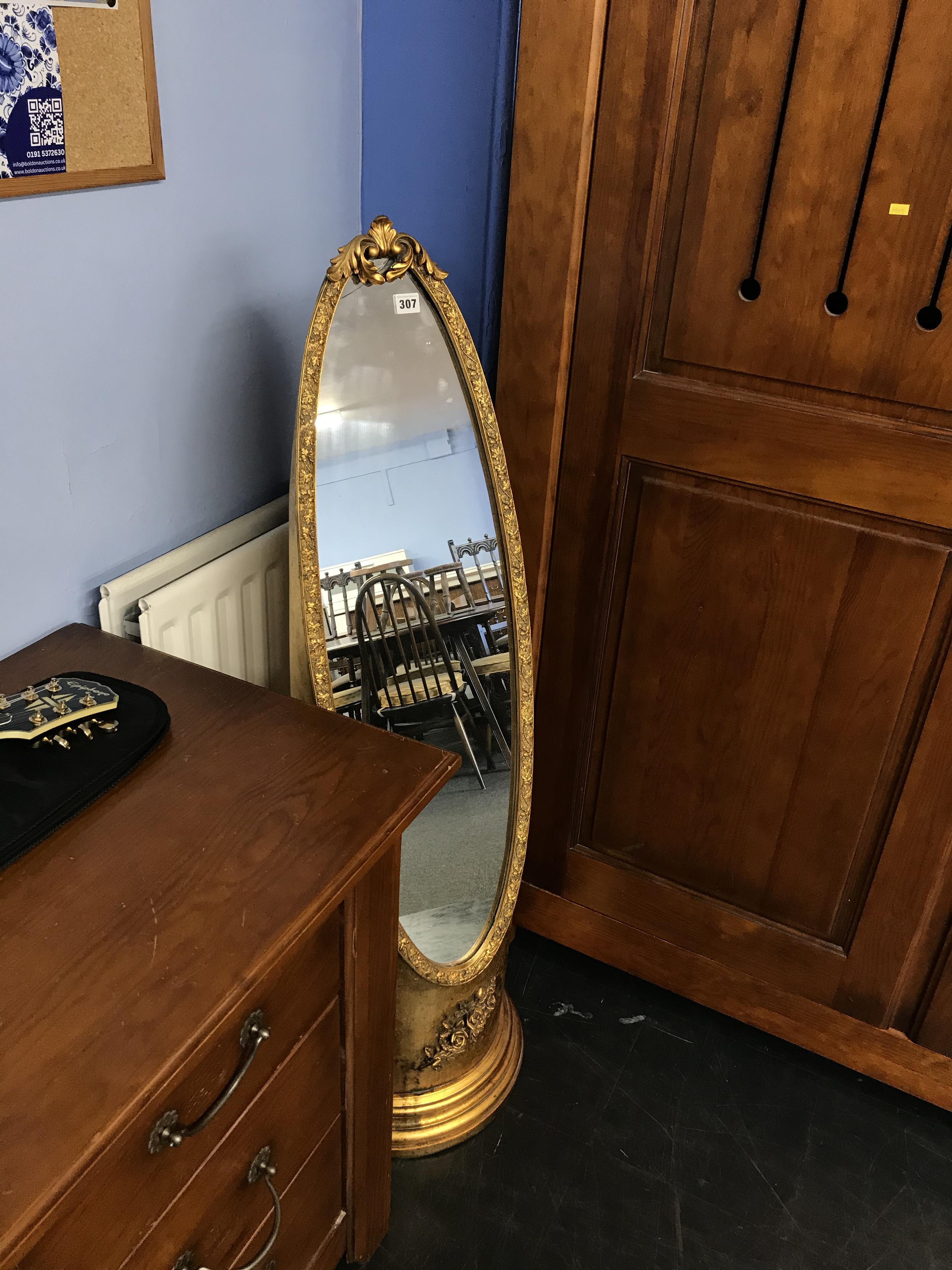 A gold coloured oval cheval mirror