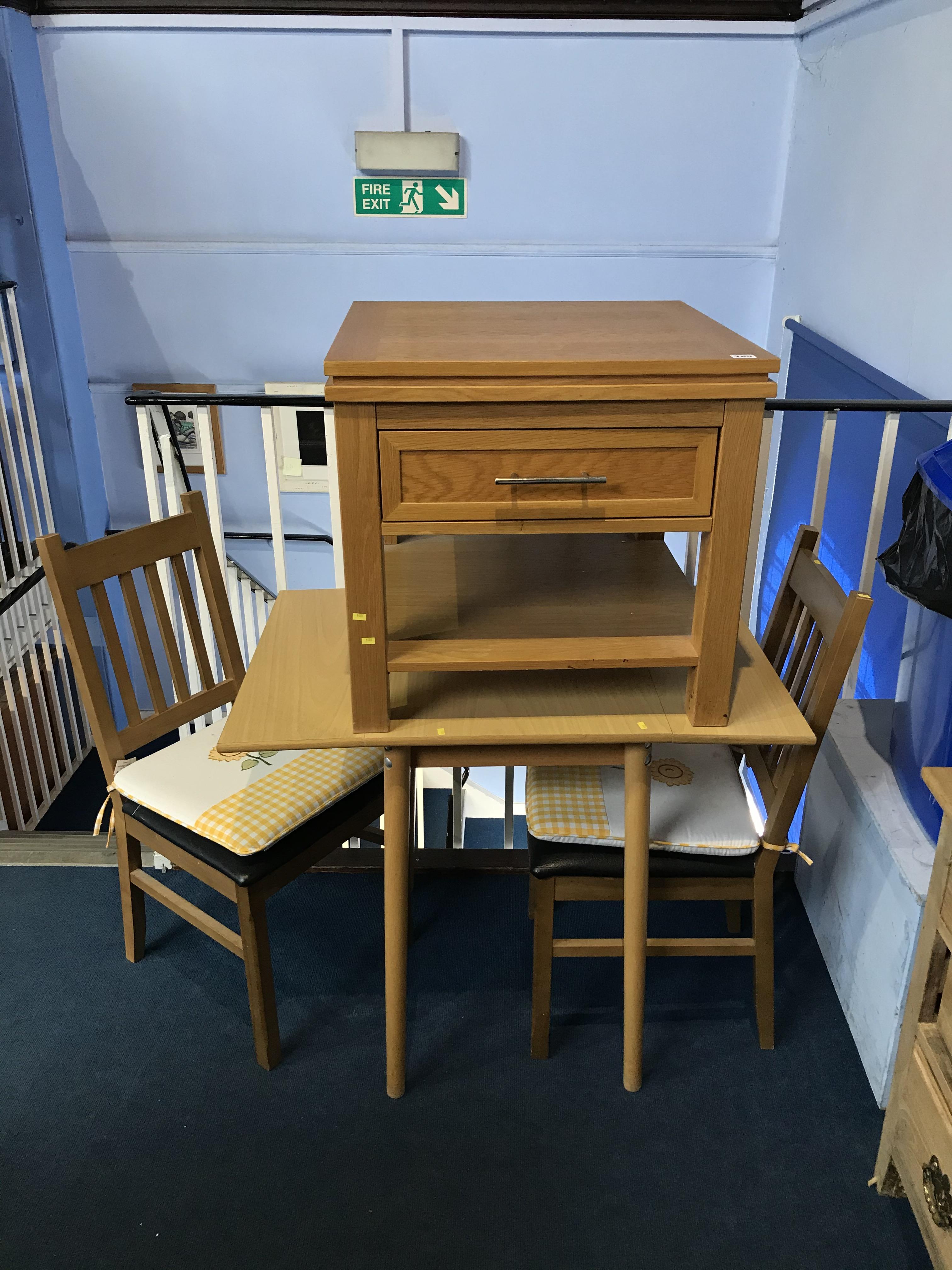 A kitchen table, two chairs and a light oak unit