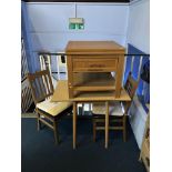 A kitchen table, two chairs and a light oak unit