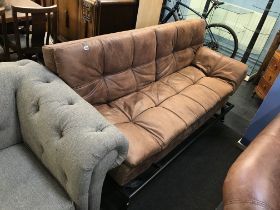 A brown leather folding bed settee