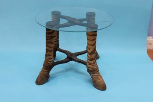 A glass top coffee table, with four zebra leg supports, D 49cm