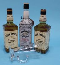 A Jack Daniel's glass, two bottles of Honey Jacks and one bottle of Winter Jack