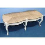 A cream and rattan long seat