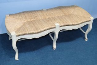 A cream and rattan long seat