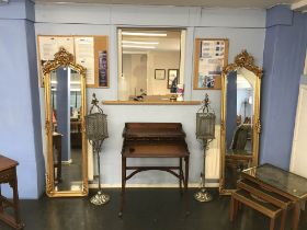 A pair of ornate and decorative narrow rectangular hall mirrors