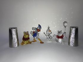 A pair of boxed Swarovski 'Ambiray Candlesticks', two Swarovski Winnie the Pooh figures, Donald Duck