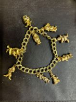 Yellow metal charm bracelet with 9ct gold heart sh