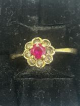 9ct Gold ring set with central red stone surrounde