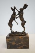 Bronze boxing hares on marble base signed